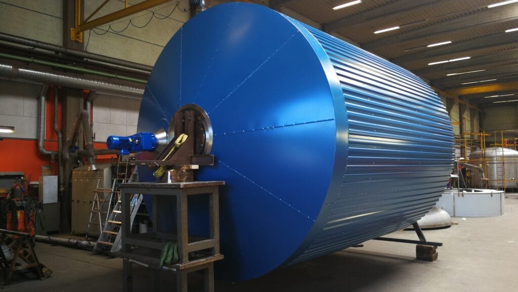 Stor blå metalcylinder i industriværksted